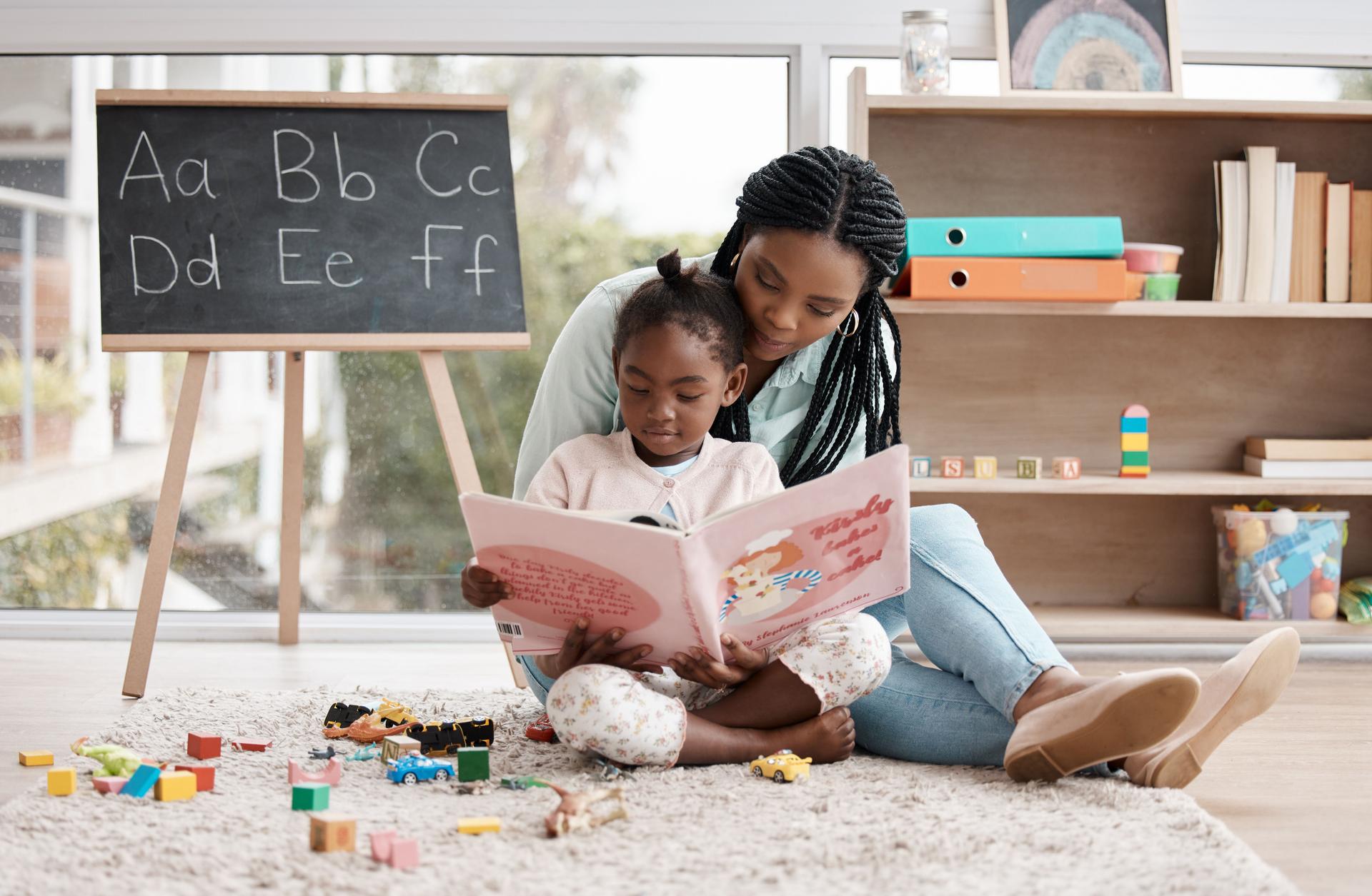 Shot of a woman reading a book to her daughter while sitting at home