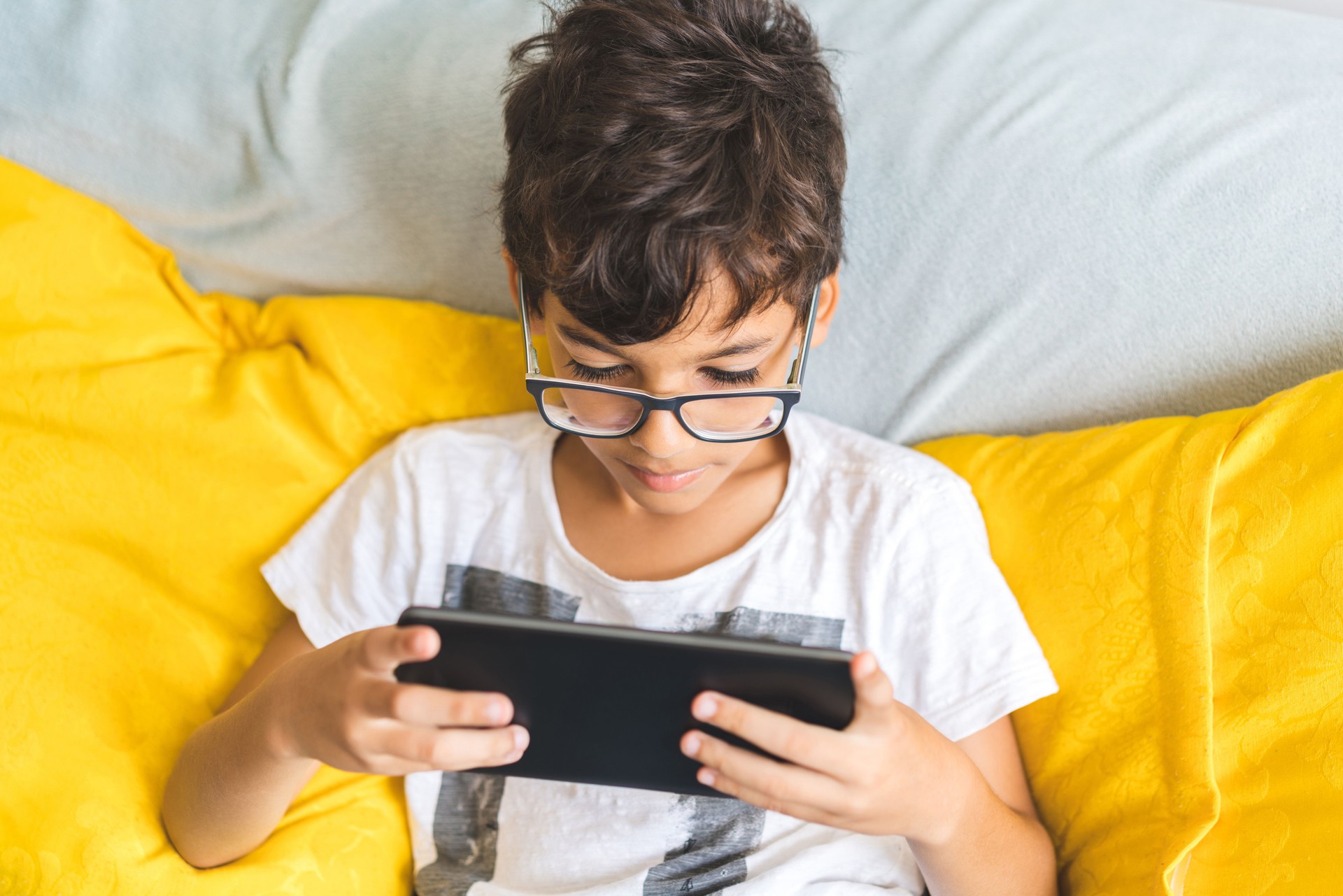 Boy with digital tablet on sofa